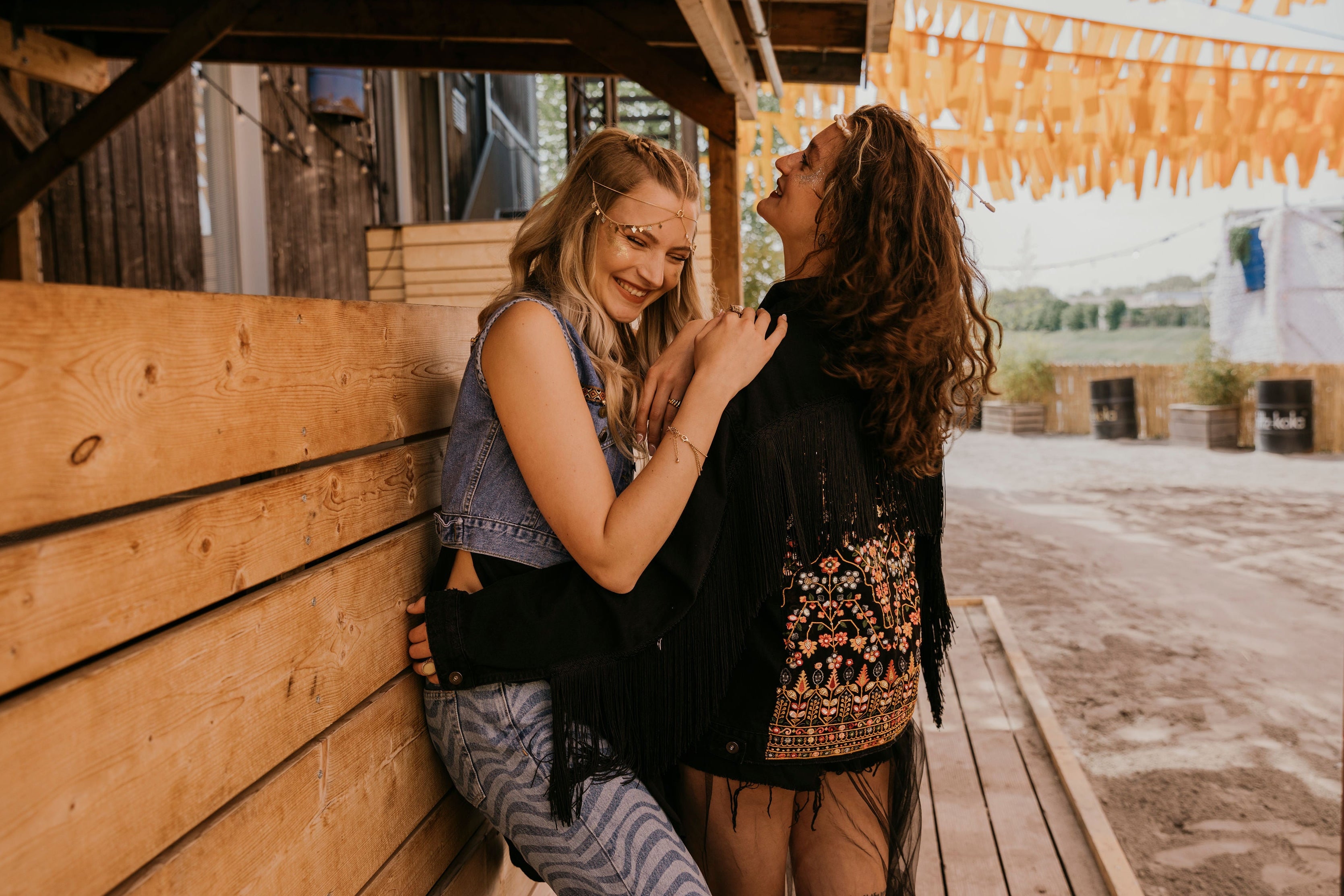 Bohogirls im Festivallook umarmen sich auf dem Festival