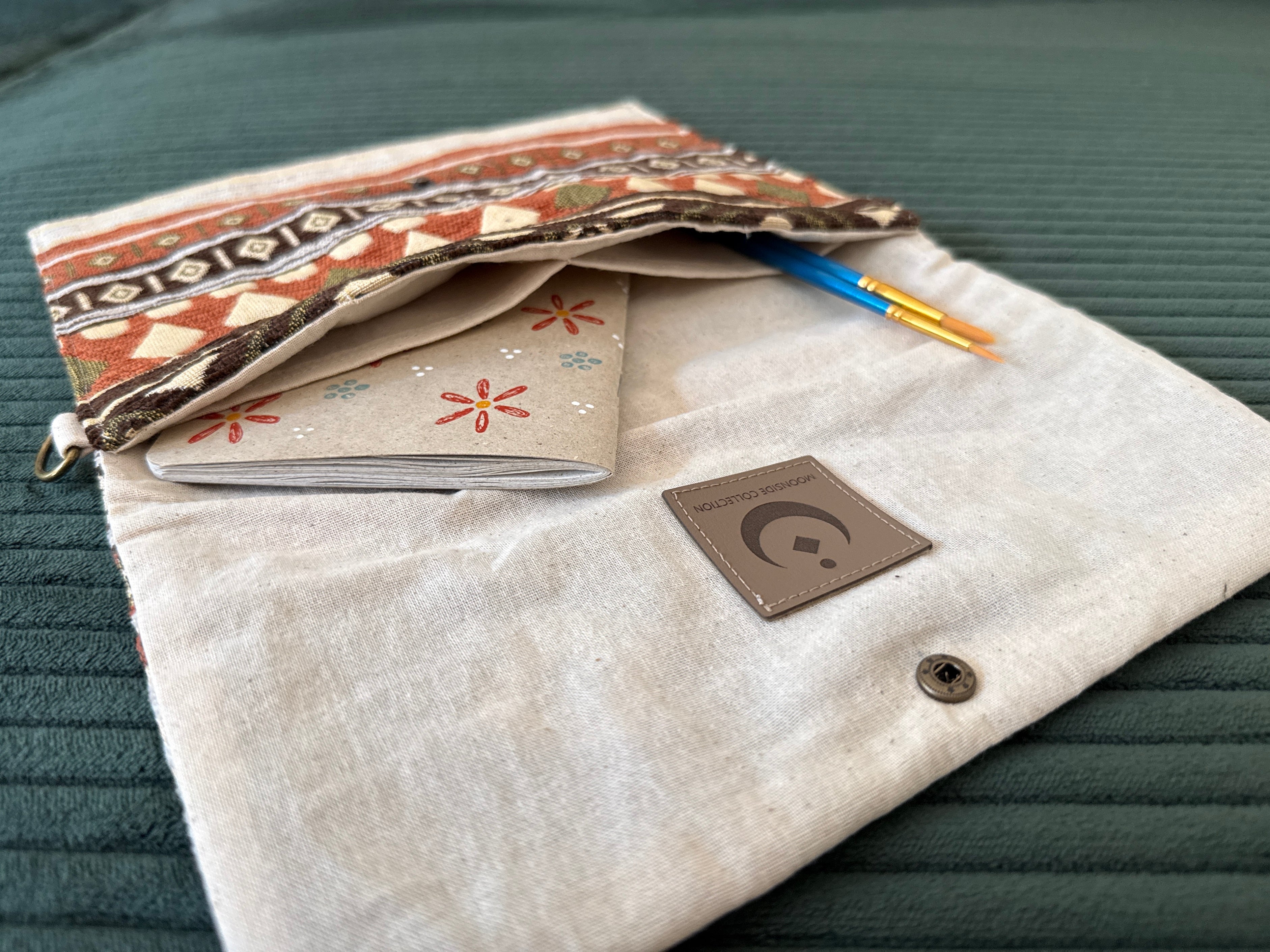 Offene Tasche mit Notizbuch und Pinseln in den Innentaschen