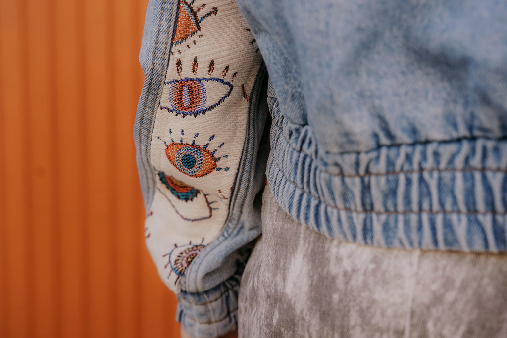 Detail von Jeansjacken Ärmel mit Jacquard-Stoffeinsatz mit Augenprint