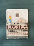 Bild von einer geöffneten Boho-Clutch mit Notizbuch und zwei Pinseln