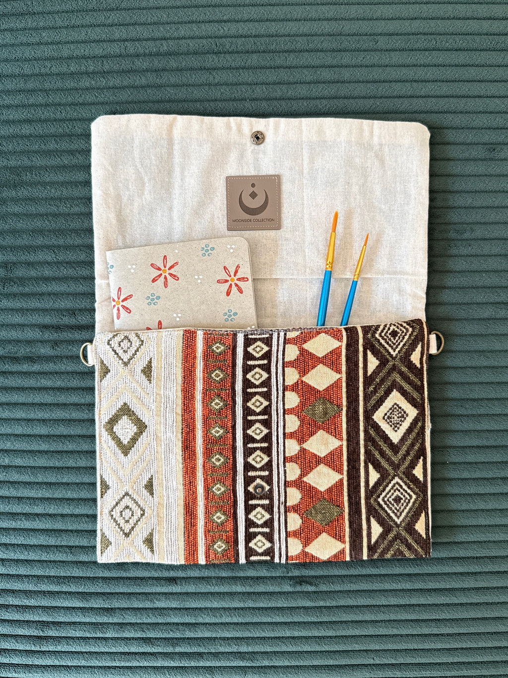 Offene Tasche im Hippie-Stil mit Notizbuch und Pinseln