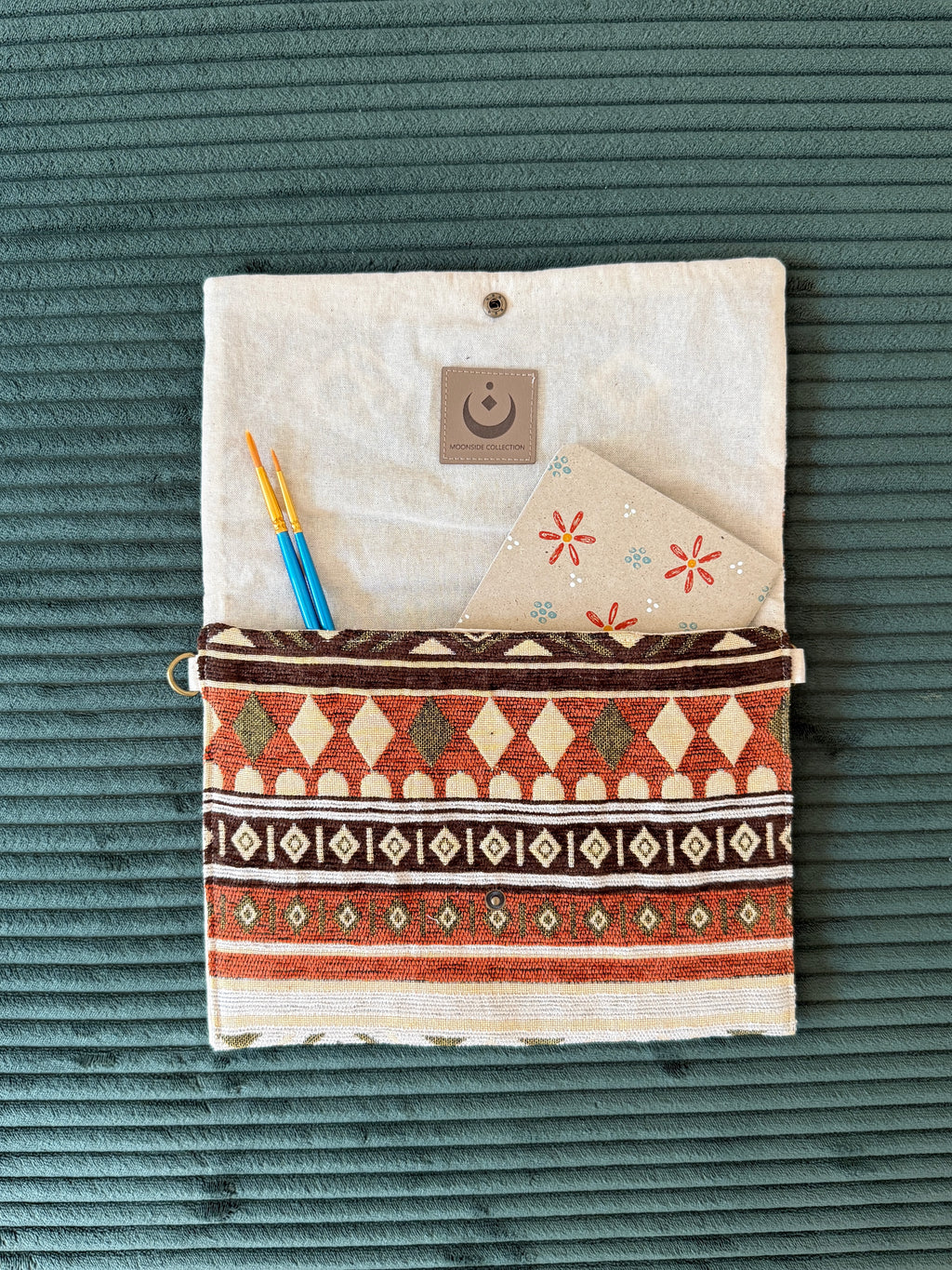 Offene Tasche im Hippie-Stil mit Notizbuch und Pinseln
